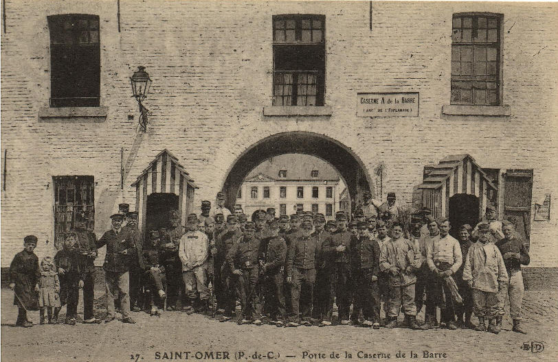 A l'entrée de la caserne de la Barre, de nombreux militaires posent pour le photographe ainsi que quelques civils sur la gauche. Cette caserne fut commencée en 1675 et terminée en 1680 aprés la prise de St Omer par Louis XIV. 